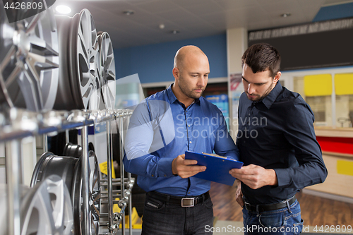 Image of customer and salesman at car service or auto store