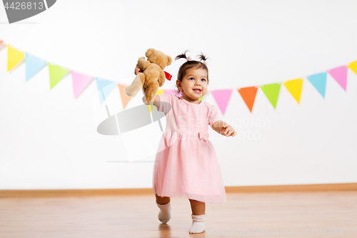 Image of happy baby girl with teddy bear on birthday party