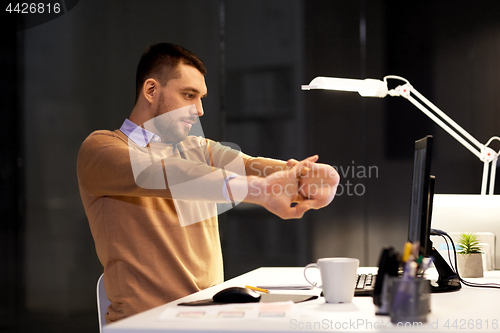 Image of man with computer working late at night office
