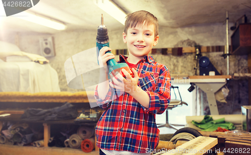 Image of happy little boy with drill at workshop