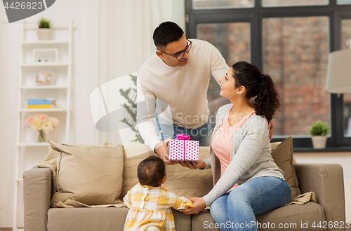 Image of happy family with birthday present at home