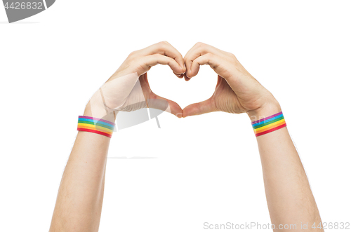 Image of male hands with gay pride wristbands showing heart