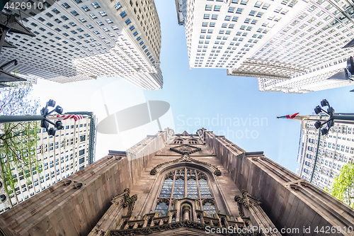 Image of Wide angle upward view of Trinity Church at Broadway and Wall Street with surrounding skyscrapers, Lower Manhattan, New York City, USA