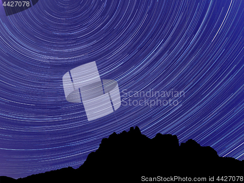 Image of Long exposure image showing Night sky star trails over mountains