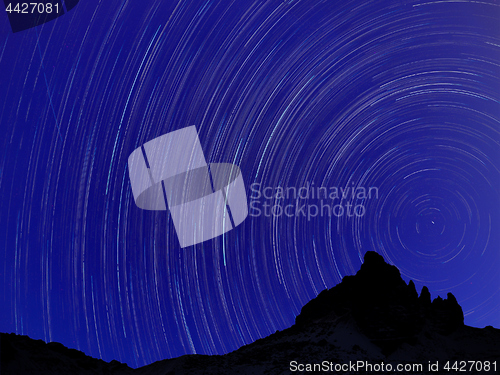 Image of Long exposure image showing Night sky star trails over mountains