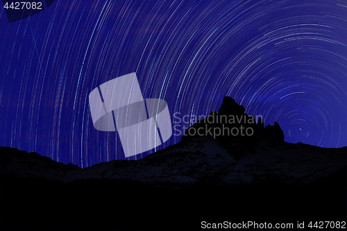 Image of Long exposure image showing Night sky star trails over mountains