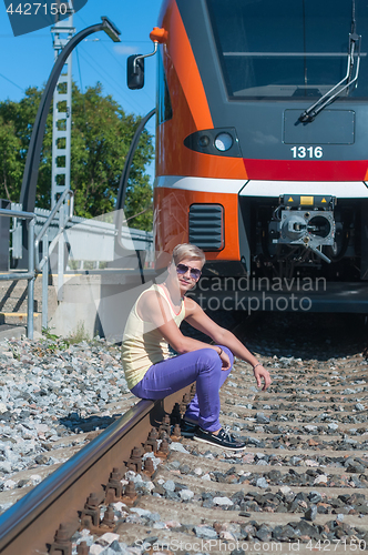 Image of Young trendy guy in front of train