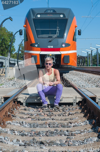 Image of Young trendy guy in front of train