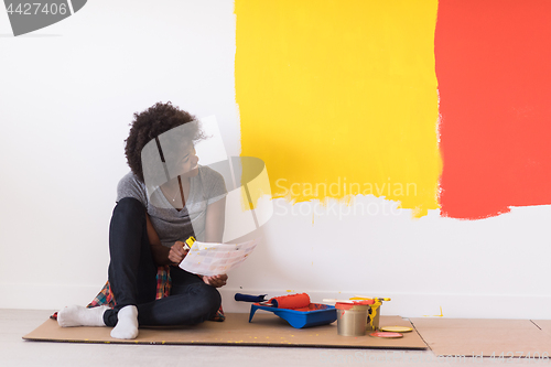 Image of back female painter sitting on floor