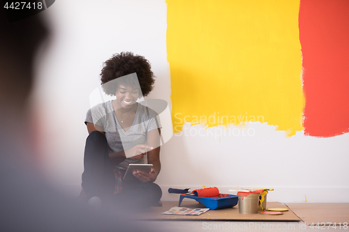 Image of back female painter sitting on floor