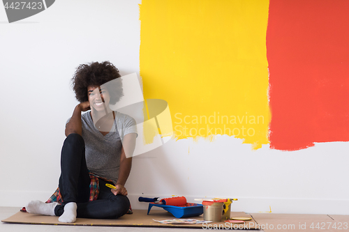 Image of back female painter sitting on floor