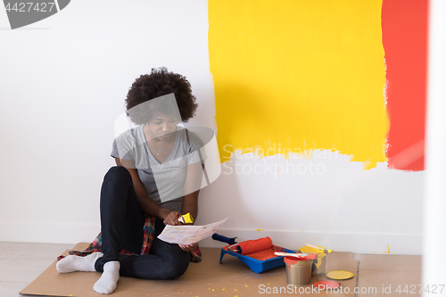 Image of back female painter sitting on floor