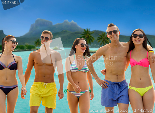 Image of smiling friends in sunglasses on summer beach
