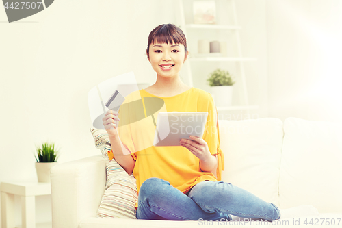 Image of happy asian woman with tablet pc and credit card