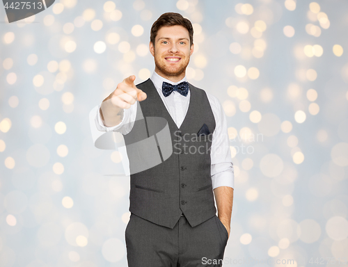 Image of man in suit pointing finger at you over lights