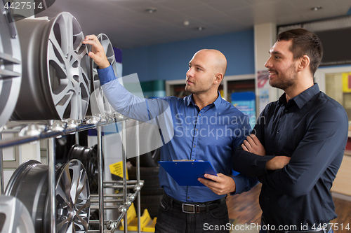 Image of customer and salesman at car service or auto store