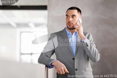 Image of businessman calling on smartphone at office