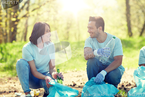 Image of volunteers with garbage bags cleaning park area