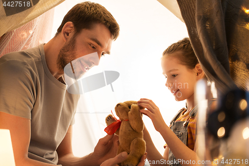 Image of happy family playing with toy in kids tent at home