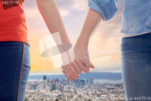Image of gay couple holding hands over san francisco city