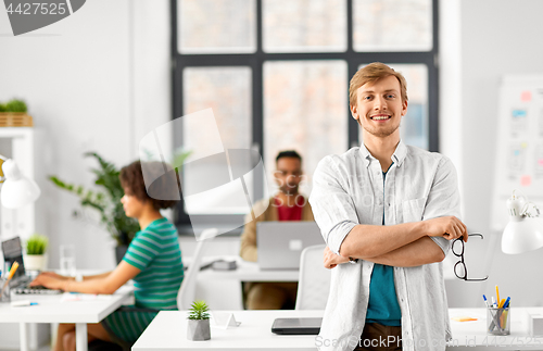 Image of happy smiling man with glasses at office