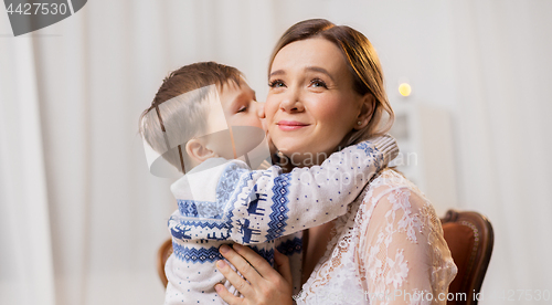 Image of happy little son kissing his mother