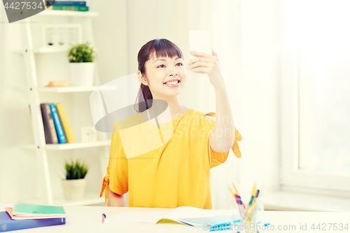 Image of asian woman student taking selfie with smartphone