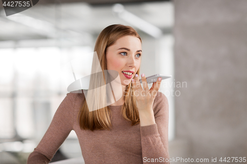 Image of woman using voice recorder on smartphone at office