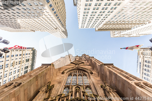 Image of Wide angle upward view of Trinity Church at Broadway and Wall Street with surrounding skyscrapers, Lower Manhattan, New York City, USA