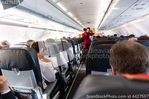 Image of Interior of commercial airplane with passengers on their seats during flight.