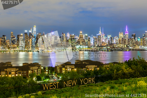 Image of West New York City midtown Manhattan skyline view from Boulevard East Old Glory Park over Hudson River at dusk.