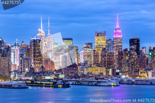 Image of West New York City midtown Manhattan skyline view from Boulevard East Old Glory Park over Hudson River at dusk.