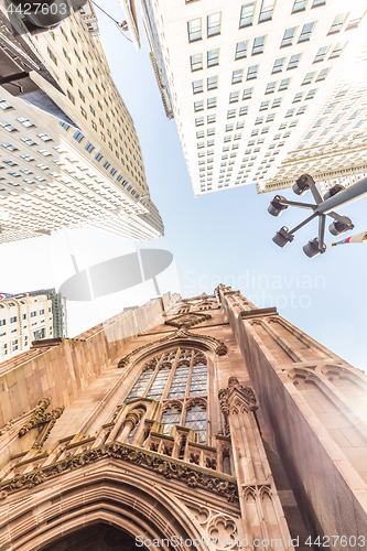 Image of Wide angle upward view of Trinity Church at Broadway and Wall Street with surrounding skyscrapers, Lower Manhattan, New York City, USA