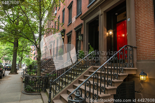 Image of Row of old brownstone buildings along an empty sidewalk block in the Greenwich Village neighborhood of Manhattan, New York City NYC