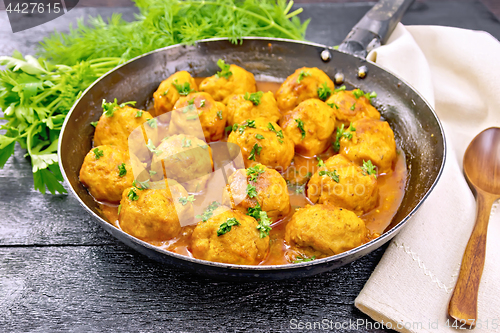 Image of Meatballs in pan with sauce on board