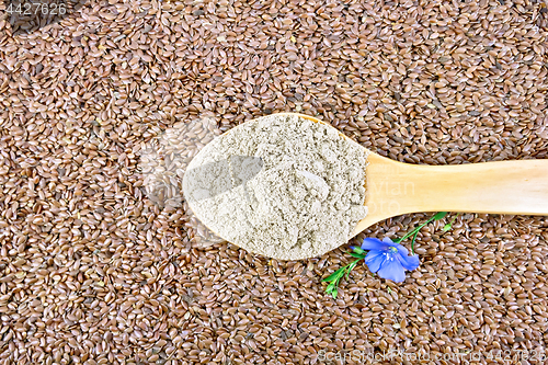Image of Flour linen in wooden spoon with flower on seeds