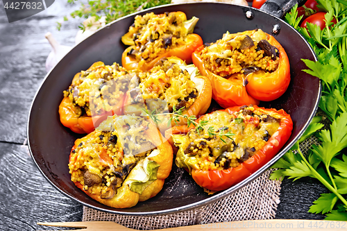 Image of Pepper stuffed with mushrooms and couscous in pan on board