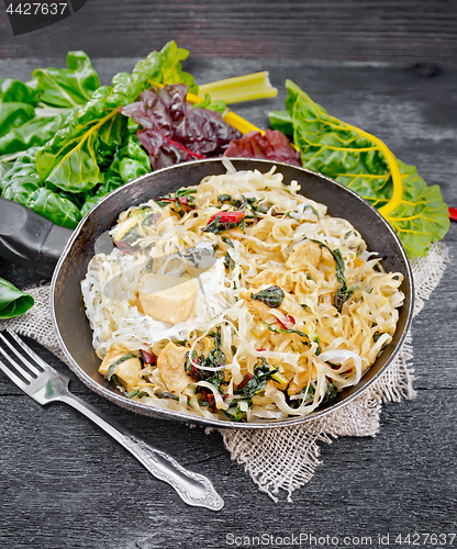 Image of Funchoza with chard and meat in pan on wooden board