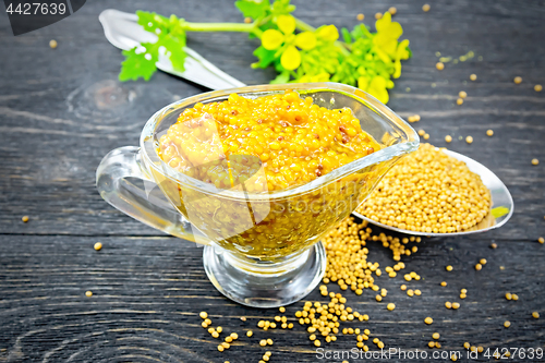 Image of Sauce mustard Dijon in sauceboat with flower on wooden board