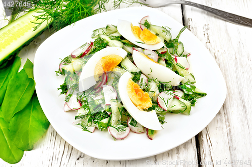 Image of Salad with radish and egg in plate on table
