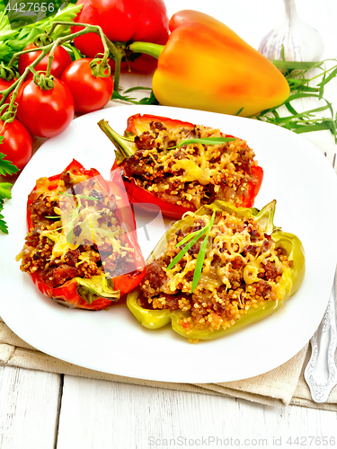 Image of Pepper stuffed with meat and couscous in white plate on board