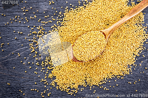Image of Mustard seeds in spoon on board top