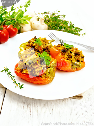 Image of Pepper stuffed with mushrooms and couscous in white plate on boa