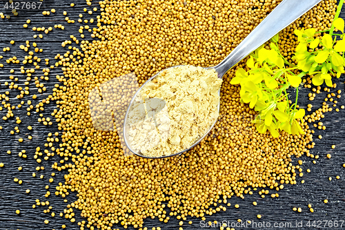 Image of Mustard powder in spoon with flower on board top