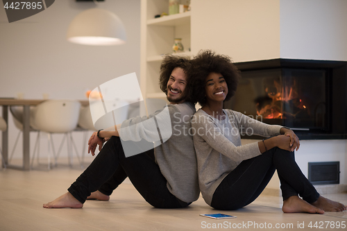 Image of multiethnic couple with tablet computer on the floor