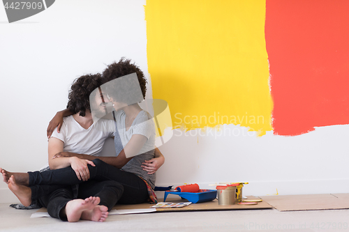 Image of young multiethnic couple relaxing after painting