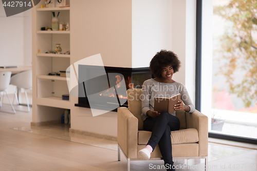 Image of black woman at home reading book