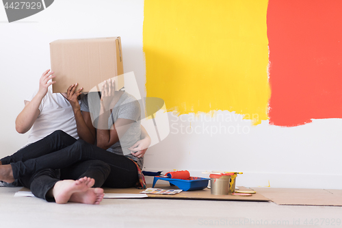 Image of young multiethnic couple playing with cardboard boxes