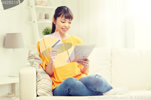 Image of happy asian woman with tablet pc and credit card