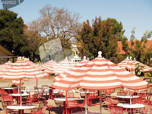 Image of Umbrellas over empty tables and chairs outdoor cafe